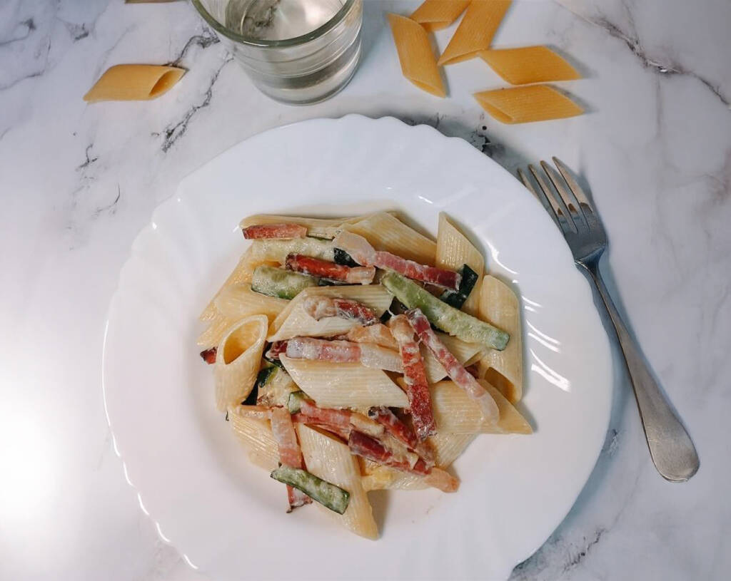 Pasta con speck y calabacín cremosa preparada con ingredientes italianos auténticos