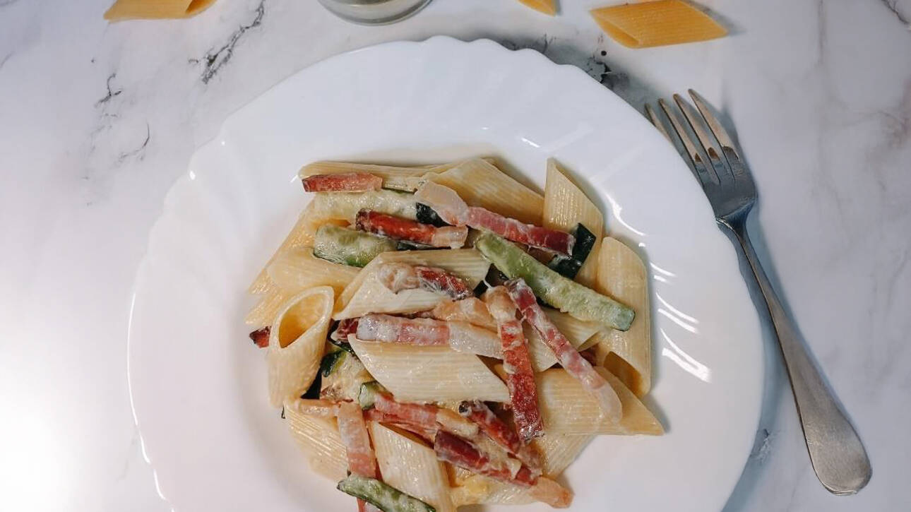 Pasta con speck y calabacín cremosa preparada con ingredientes italianos auténticos