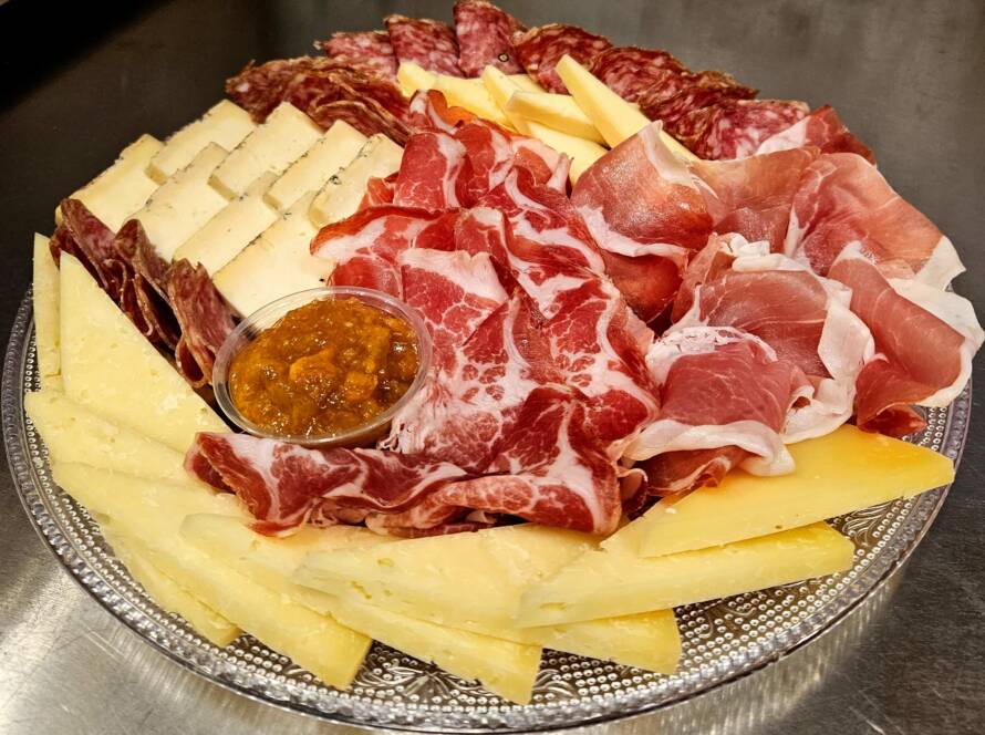 Tabla gourmet con quesos y embutidos italianos en Valencia, ideal para reuniones y celebraciones, preparada con productos auténticos y presentación elegante.