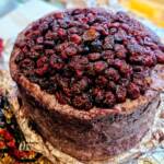 Pieza de queso azul italiano Blu 61 afinado en vino Raboso y cubierto de arándanos rojos sobre tabla gourmet bronce en world cheese award 2025