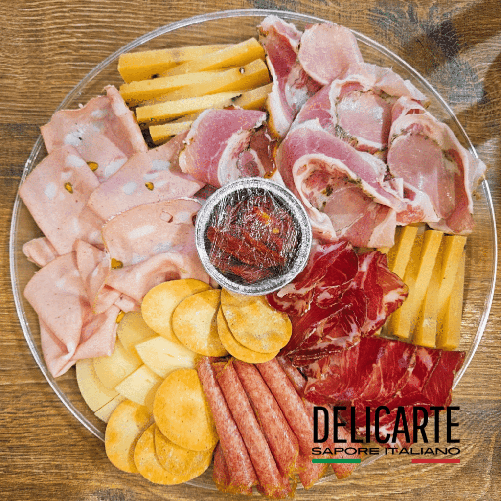 tabla de quesos y embutidos italianos sobre una mesa.